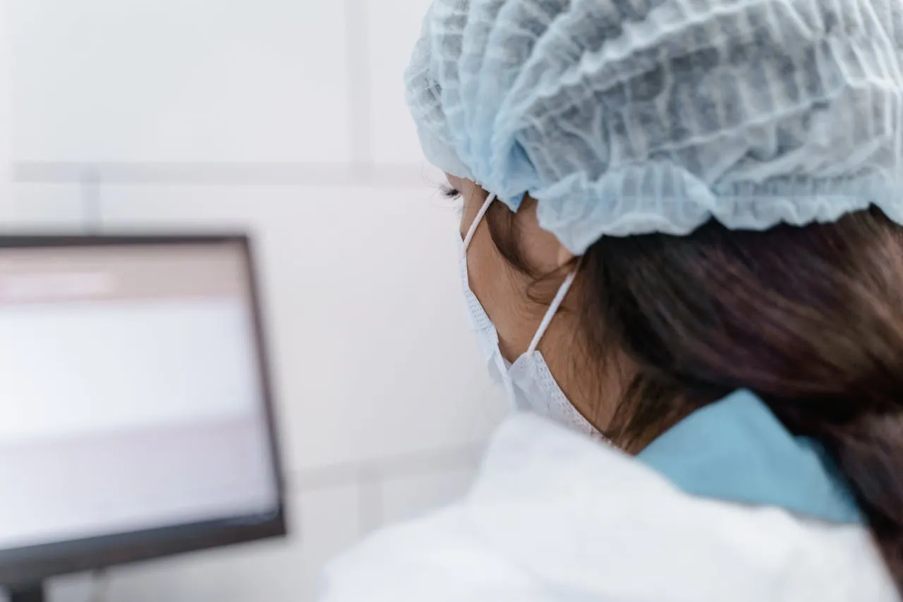 Lab workers analyzing results with computer and microscope